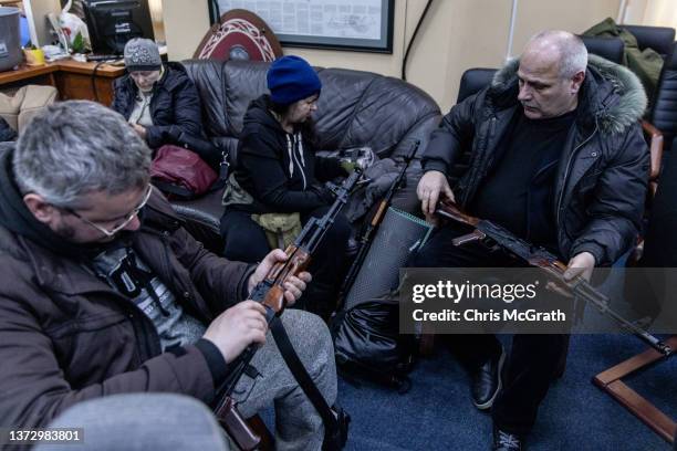 Civilian volunteers check their guns at a Territorial Defence unit registration office on February 26, 2022 in Kyiv, Ukraine. Explosions and gunfire...