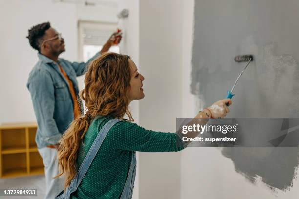 young  couple painting walls - painting wall stock pictures, royalty-free photos & images