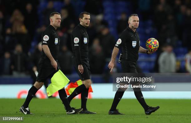 Referee Paul Tierney leaves the pitch with the match ball after the Premier League match between Everton and Manchester City at Goodison Park on...