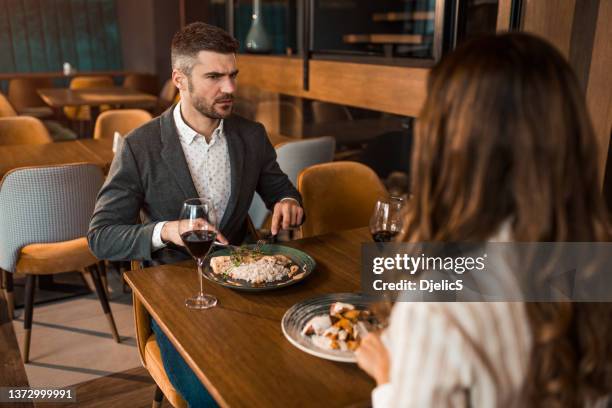 arguing couple eating lunch in a restaurant. - bad dating stock pictures, royalty-free photos & images