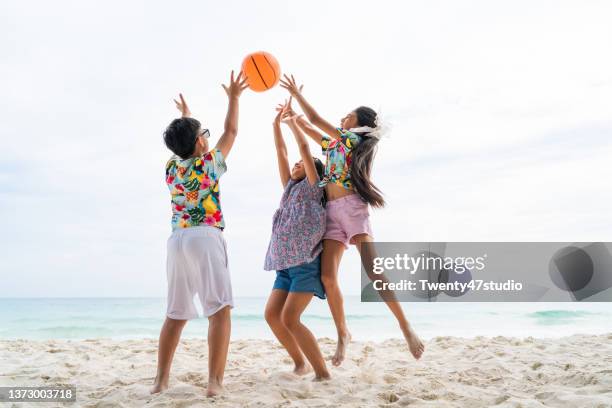 children playing beach ball on the beach - beach volleyball friends stock pictures, royalty-free photos & images