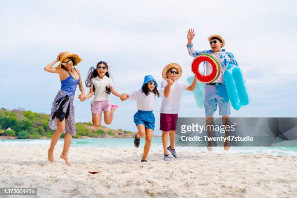happy asian family enjoying summer vacation on the beach - tourist mother father child thailand stock pictures, royalty-free photos & images