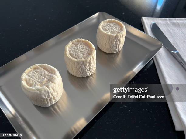 three goat cheese in a silver plate with black background - heritage round three stock pictures, royalty-free photos & images