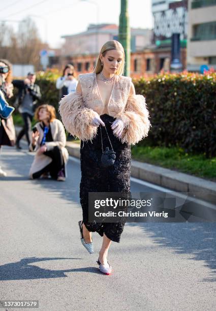 Leonie Hanne is seen wearing black laced skirt, beige vest, silver heels, gloves, black bag outside Gucci fashion show during the Milan Fashion Week...