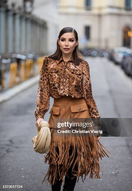 Karina Nigay seen wearing blouse with animal print, brown skirt with fringes, beige Bottega Veneta bag, black high knee boots outside Elisabetta...