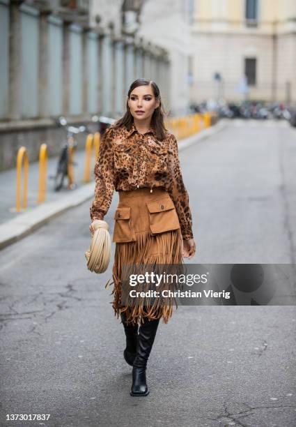 Karina Nigay seen wearing blouse with animal print, brown skirt with fringes, beige Bottega Veneta bag, black high knee boots outside Elisabetta...