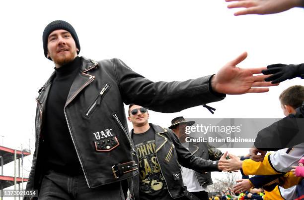 Yakov Trenin, Tanner Jeannot and Michael McCarron of the Nashville Predators high five fans as they arrive for the 2022 NHL Stadium Series game...