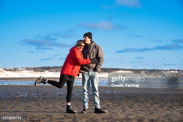 mother and teen son out for a winter beach walk and talk - mature woman and son imagens e fotografias de stock