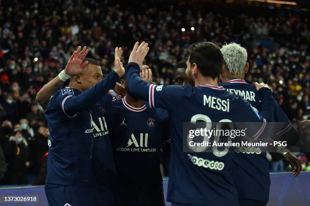 Kylian Mbappe of Paris Saint-Germain is congratulated by teammates Neymar Jr and Leo Messi after scoring during the Ligue 1 Uber Eats match between...