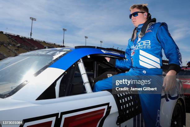 Garrett Smithley, driver of the Jacob Companies Ford, enters his car during qualifying for the NASCAR Cup Series Wise Power 400 at Auto Club Speedway...