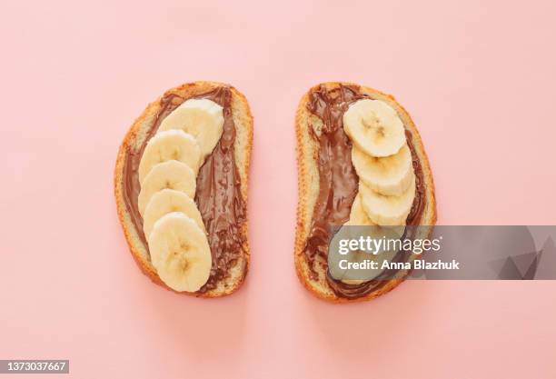 two bread toasts with chocolate spread and banana slices, breakfast or lunch meal. - pindakaas stockfoto's en -beelden