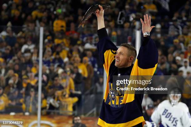 Former Nashville Predators player Pekka Rinne holds up a catfish before the ceremonial puck drop during the 2022 Navy Federal Credit Union NHL...