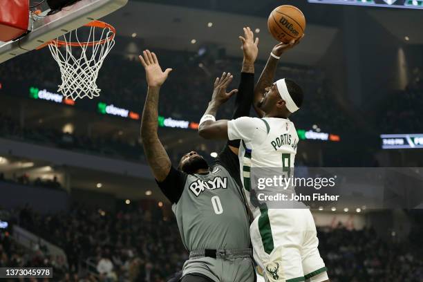 Bobby Portis of the Milwaukee Bucks goes in for a score over Andre Drummond of the Brooklyn Nets during the first half of a game at Fiserv Forum on...