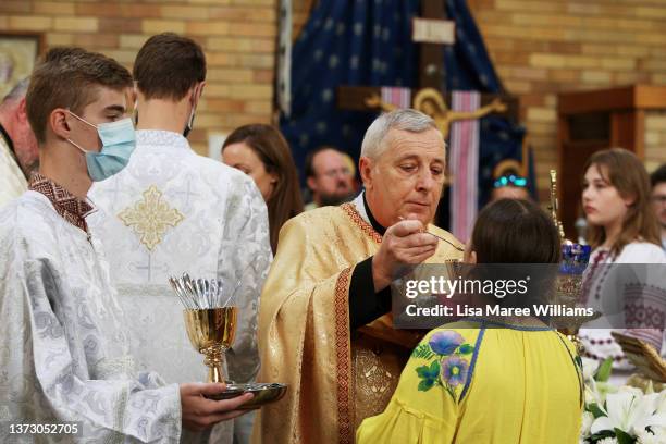 Members of the congregation wait in line to receive communion during a prayer service at St Andrew's Ukrainian Catholic Church, Lidcombe on February...