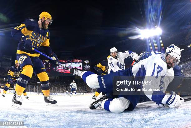 Alex Killorn of the Tampa Bay Lightning falls to the ice after being crossed checked by Mattias Ekholm of the Nashville Predators during the second...