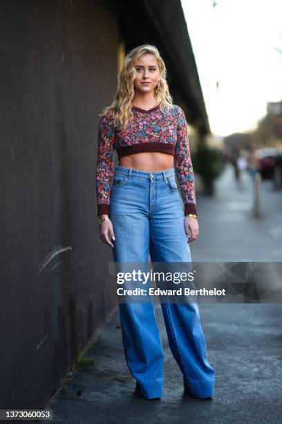 Valentina Ferragni wears gold earrings, a pale purple plastic earrings, a gold large chain necklace, a dark brown with pink / blue / green flower...