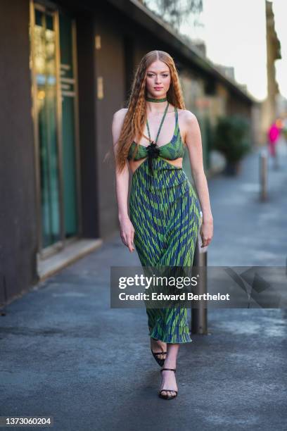 Larsen Thompson wears a green and navy blue print pattern N-neck / tank-top / necklace / cut-out waist / tube long dress, black shiny leather strappy...