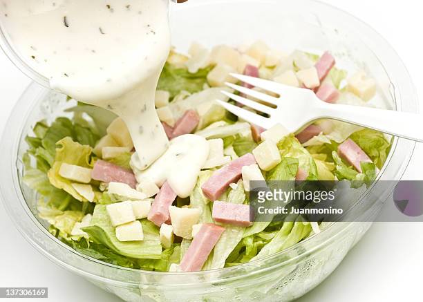 salade avec morceaux de jambon et vinaigrette étant versé sur - vinaigrette dressing photos et images de collection