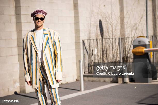 Guido Milani poses ahead of the Marni fashion show wearing black sunglasses and a beige, yellow and bue suit during the Milan Fashion Week...
