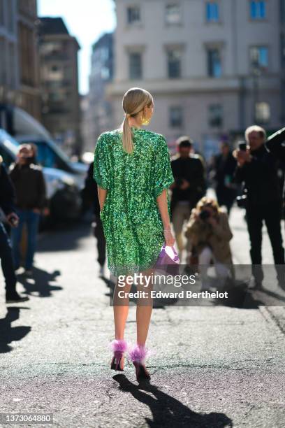 Leonie Hanne wears silver and rhinestones earrings from Balenciaga, a green shiny sequined oversized t-shirt dress, rhinestones bracelets, a pale...