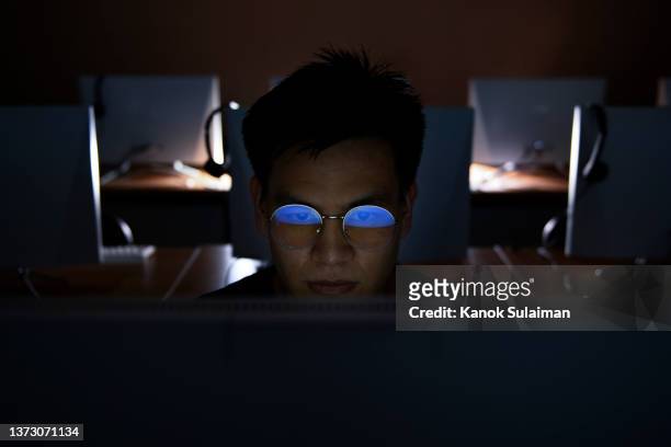 computer hacker stealing information with computer - asian man online stock pictures, royalty-free photos & images