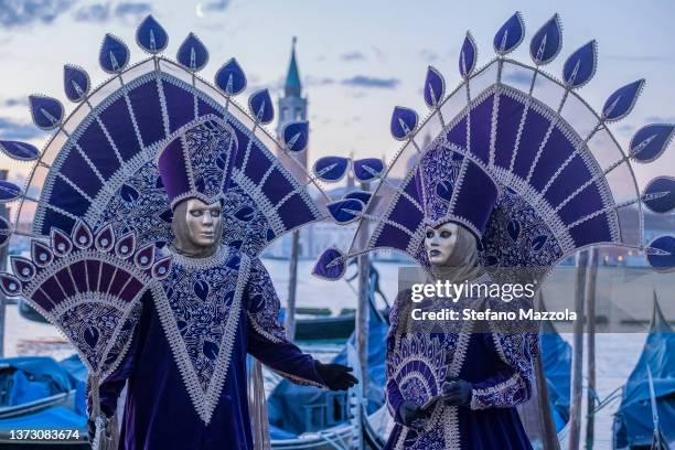 Masked revelers pose in St. Mark's Square on February 27, 2022 in Venice, Italy. The theme for the 2022 edition of the Venice Carnival is "Remember...