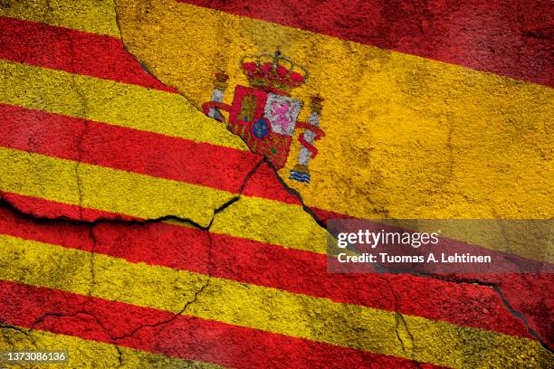 full frame photo of a weathered flags of catalonia and spain painted on a cracked wall. - spain flag stock pictures, royalty-free photos & images