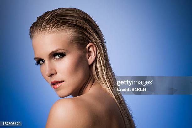 sexy model with wet hair posing against a blue background - woman wet look stock pictures, royalty-free photos & images