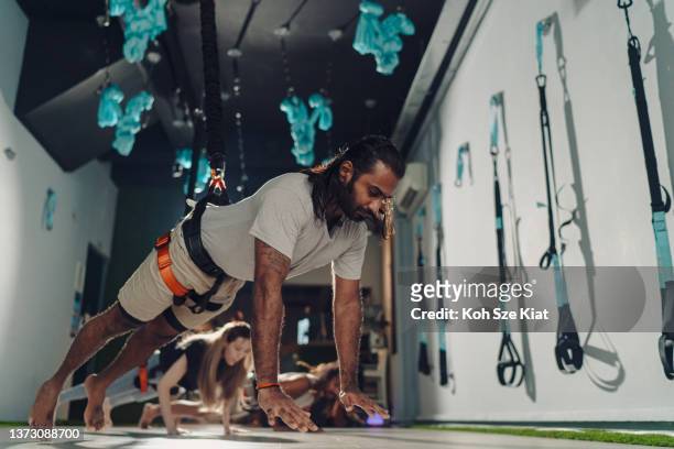indoor-fitnessstudio trainiert mit bungee-kabel - bungee cord stock-fotos und bilder