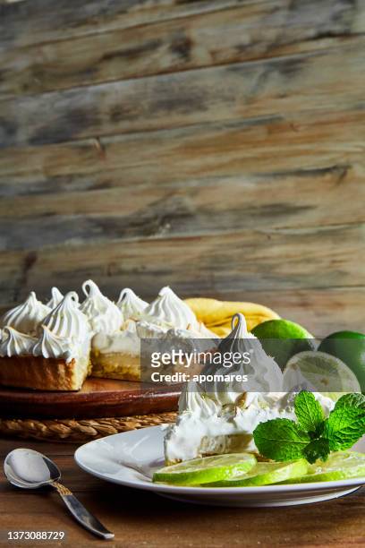 slice of lemon meringue pie on rustic wooden background - merengue imagens e fotografias de stock