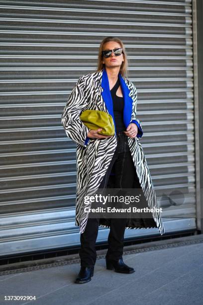 Guest wears black sunglasses, a black asymmetric shoulder body, a black and white zebra print pattern with a royal blue electric collar long...