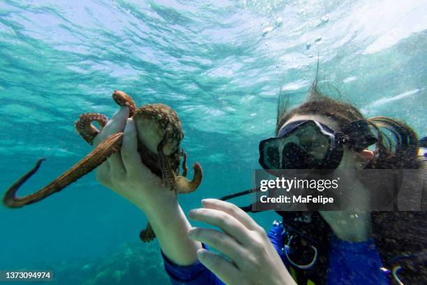 teenager-mädchen mit einem oktopus in der hand unter dem meer - scuba diving girl stock-fotos und bilder