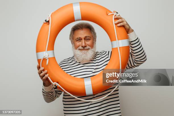 portrait of a real happy old man holding a lifebuoy - life belt stock pictures, royalty-free photos & images