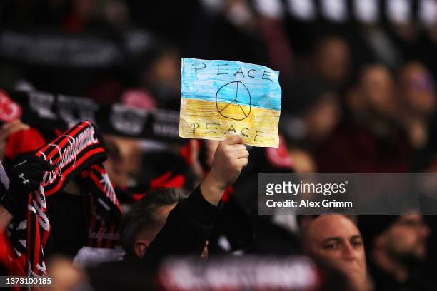 An Eintracht Frankfurt fan holds up a message of support for Ukraine during the Bundesliga match between Eintracht Frankfurt and FC Bayern München at...