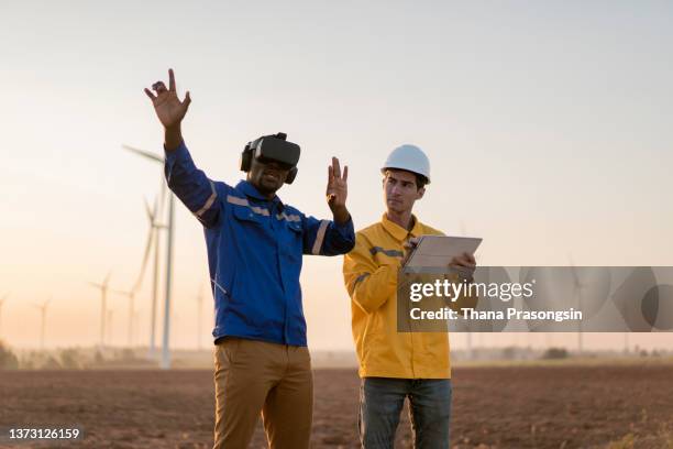 engineer standing in a field at a wind farm wearing vr glasses - ar stock pictures, royalty-free photos & images