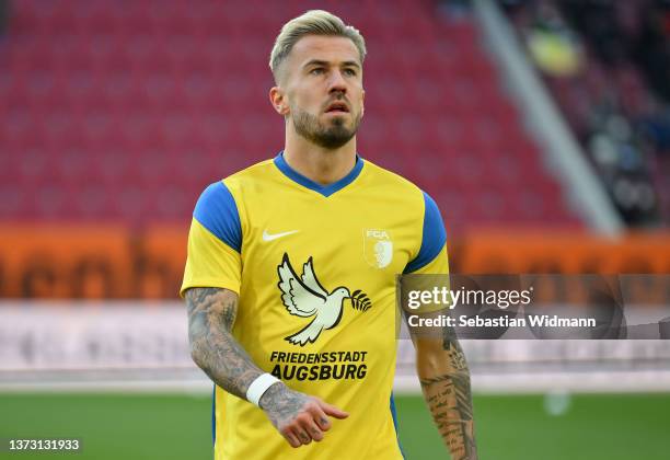 Niklas Dorsch of FC Augsburg warms up with a t-shirt with 'Peace City Augsburg' to indicate peace and sympathy with Ukraine prior to the Bundesliga...