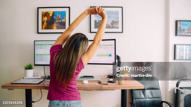 young woman with diabetes working at standing desk - woman standing exercise stockfoto's en -beelden