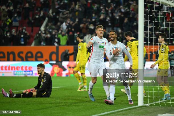 Noah-Joel Sarenren-Bazee celebrates with teammate Florian Niederlechner of FC Augsburg after scoring their team's first goal during the Bundesliga...