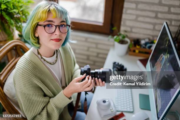 millennial photographer working on her photos at home office - photographer imagens e fotografias de stock