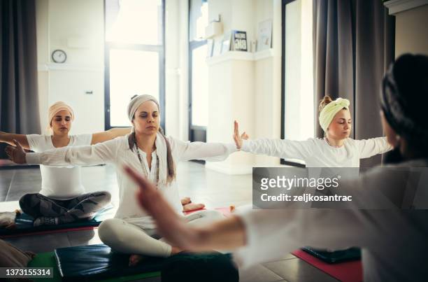 group of people meditating visualising during yoga session - tulband stockfoto's en -beelden