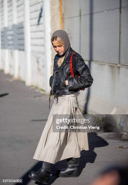 Guest is seen wearing black leather jacket, balaklava, bag, skirt outside Marni fashion show during the Milan Fashion Week Fall/Winter 2022/2023 on...