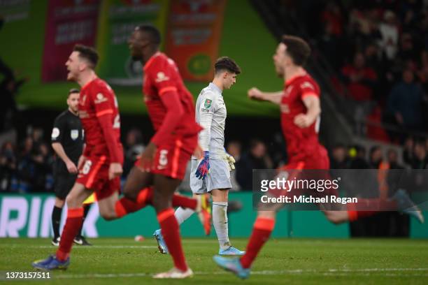 Kepa Arrizabalaga of Chelsea looks dejected after missing the deciding penalty in the penalty shoot out as players of Liverpool celebrate following...