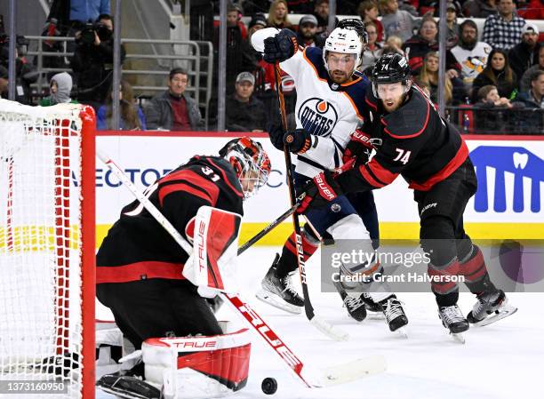 Jaccob Slavin and Frederik Andersen of the Carolina Hurricanes defend a shot by Brendan Perlini of the Edmonton Oilers during the second period of...