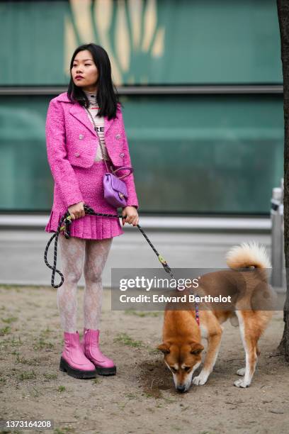 Guest wears a beige with multicolored print pattern turtleneck t-shirt, a white pearls necklace, a pink tweed cropped jacket, a matching pink tweed...