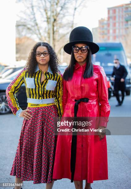 June Ambrose seen wearing big black hat, red coat and a guest wearing skirt and daughter, Summer Chamblin wears a yellow black striped button shirt...