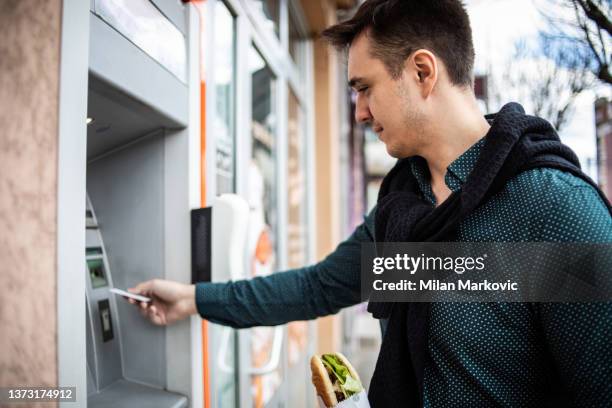 time to increase my budget in my wallet - man atm smile stock pictures, royalty-free photos & images