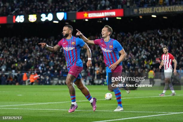 Memphis Depay of FC Barcelona celebrates with teammate Luuk de Jong after scoring their team's fourth goal during the LaLiga Santander match between...