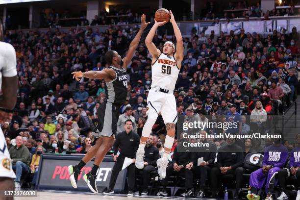 Aaron Gordon of the Denver Nuggets fires a three point basket over Harrison Barnes of the Sacramento Kings at Ball Arena on February 26, 2022 in...