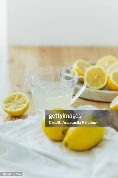 lemon squeezer and lemon juice on kitchen table. - lemon juice stock pictures, royalty-free photos & images