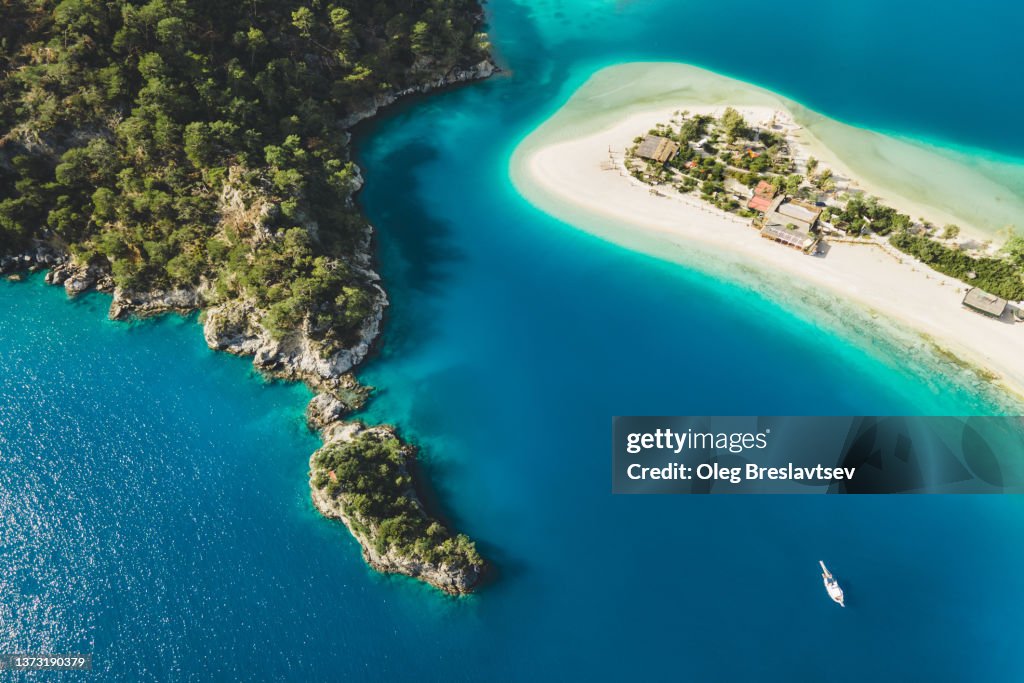 Aerial drone view of Oludeniz Blue Lagoon with turquoise sea, paradise white sand beach and tourist boat